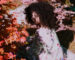 Art 87 - Femme-portant-un-afro-dans-un-décors-orange-et-rouge